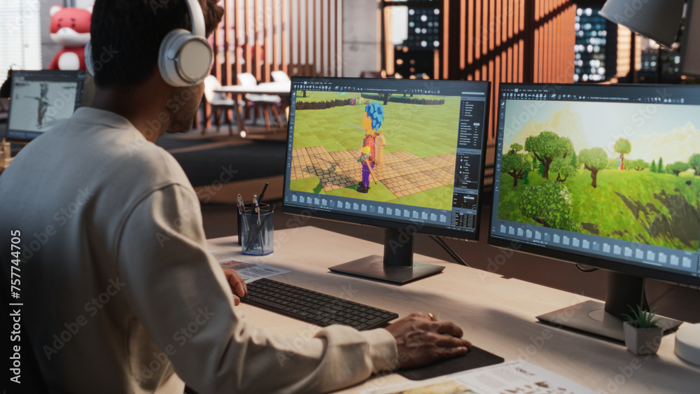 Poster Indian Male Game Designer Using Desktop Computer With 3D modelling Software To Design Characters And World For Immersive Adventure Video Game. Man Working In Game Development Company Diverse Office.