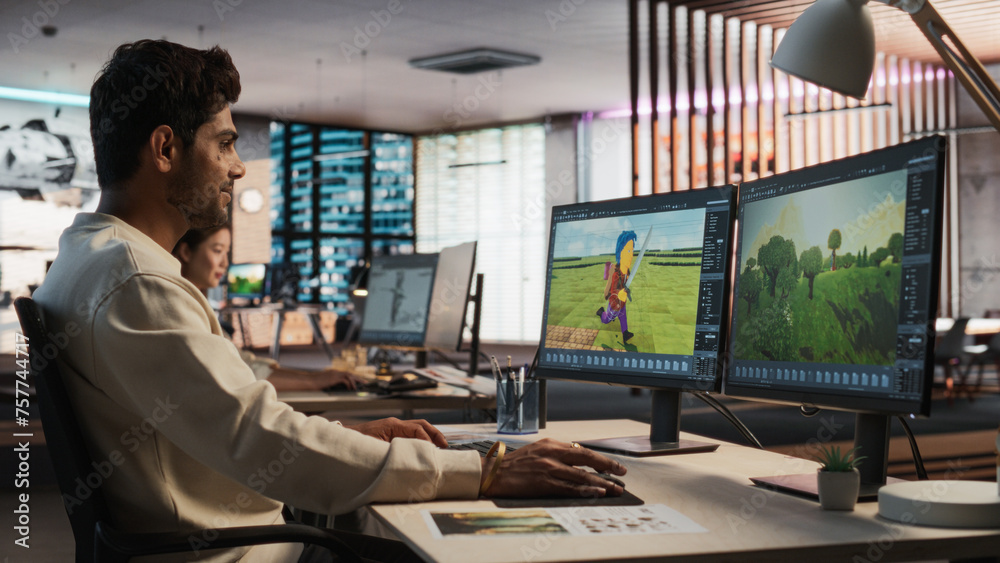 Poster Indian Male Game Designer Using Desktop Computer With 3D modelling Software To Design Characters And World For Immersive Adventure Video Game. Man Working In Game Development Company Diverse Office.