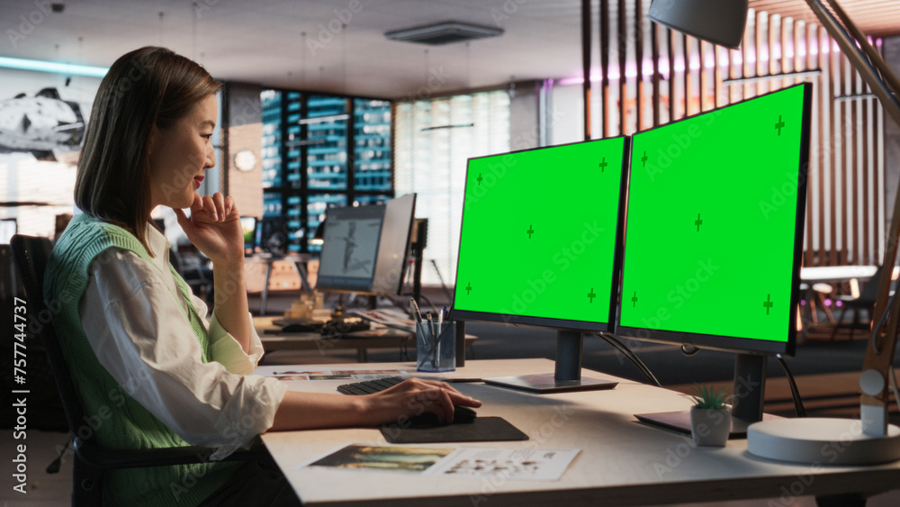 Poster Female Asian Game Designer Using Desktop Computer With Green Screen Chromakey on Display, Designing Characters In 3D Modeling Software For Survival Video Game. Woman Working In Game Development Office