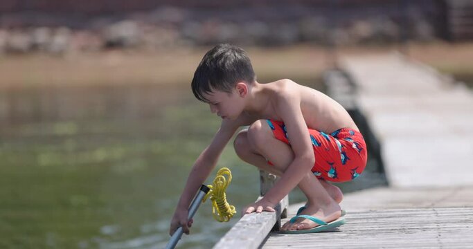 Young boy enjoys fishing off dock at cottage 