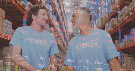 Stock market data processing over two caucasian male volunteers high fiving each other at warehouse