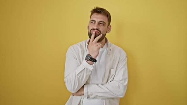 Thoughtful young hispanic man, sporting a cool casual look, standing against an isolated yellow background, exuding a doubtful expression, but seems to spark a cunning idea.