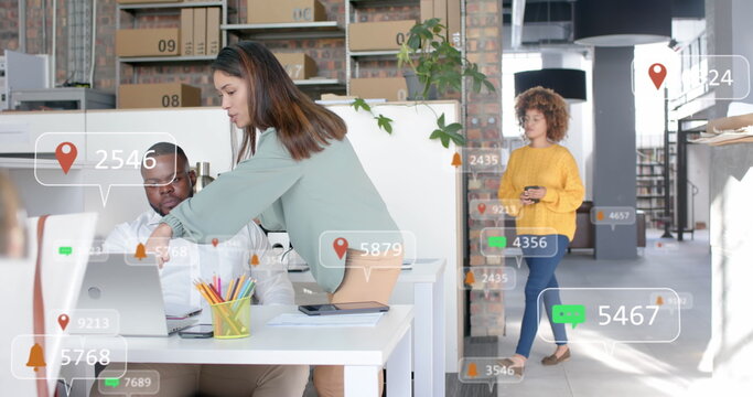 Social media notifications over diverse colleagues in discussion at laptop in casual office