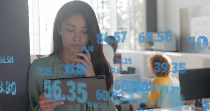 Processing data over happy biracial casual businesswoman using tablet at office