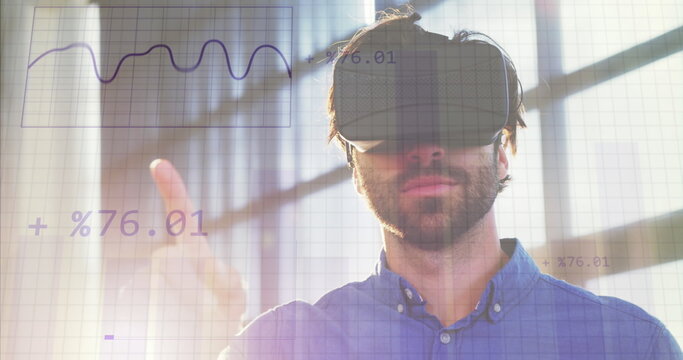 Image of financial data processing over caucasian businessman wearing vr headset in office - Powered by Adobe