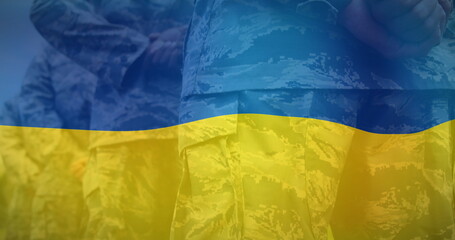 Image of flag of ukraine over midsection of diverse male soldiers - Powered by Adobe