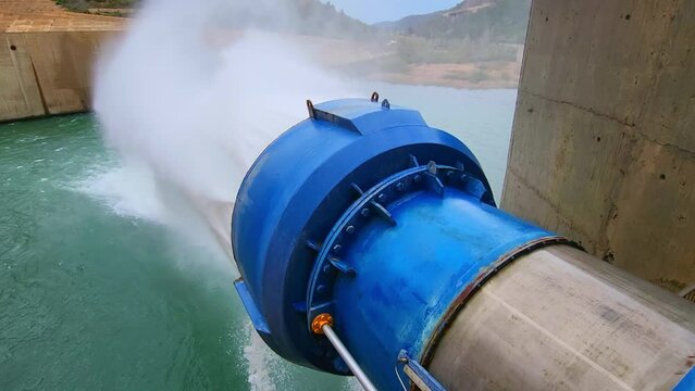 Water outlet from dam wall. Howell Bunger valve in operation. Pressurized water outlet from dam wall. Water flowing from pumping in reservoir.