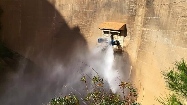 Closing of water outlet valve on dam wall. Howell Bunger valve opening. Closure of pressurized water outlet from dam wall.