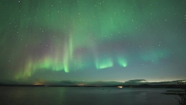 A magnificent display of the northern lights in the dark winter sky in the timelapse video.