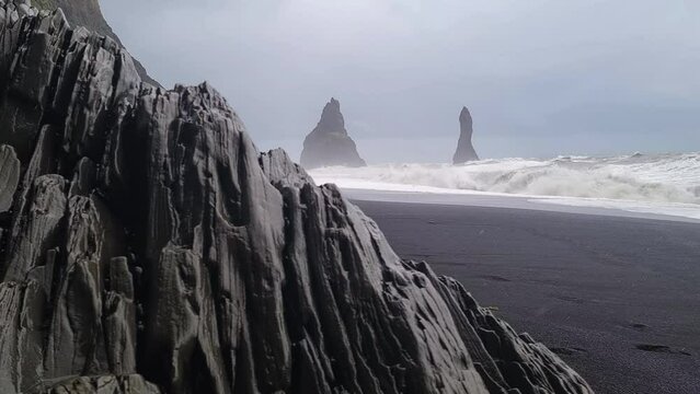 Reynisfjara, Iceland. Black Sand Beach, Basalt Rocks and Rough Sea Waves on Cold Snowy Day