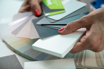 A designer carefully selects laminated or worktop board samples, focusing on colors for interior...