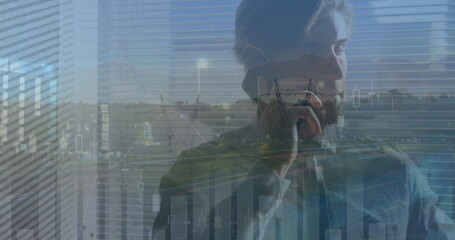 Image of financial graph over caucasian businessman using smartphone