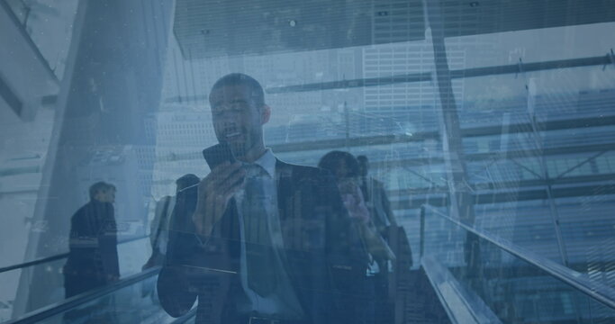 Image of financial graph over happy biracial businessman using smartphone