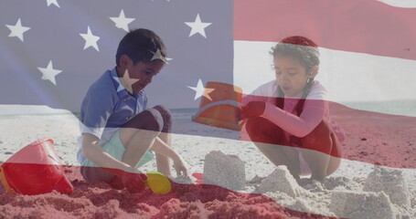 Image of flag of united states of america over biracial boy and girl playing with sand on beach