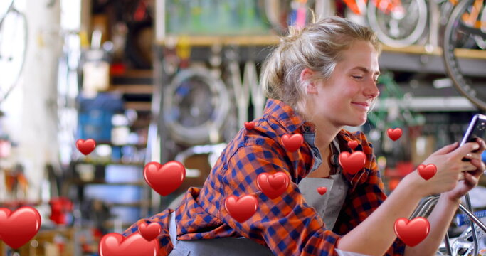 Female bike mechanic texts with hearts flying around her in a digital 4k composite.