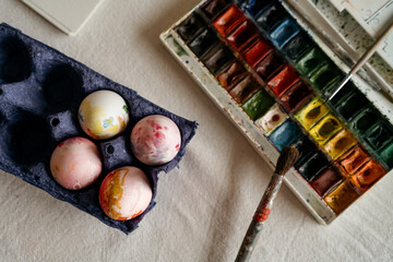 Top view of Hand-painted eggs and paints on the table