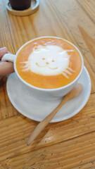 Hot Thai tea in a cup decorated with a cute cat is placed on the table. morning drink