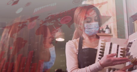 Image of coronavirus cells over caucasian female hairdresser and woman wearing face masks