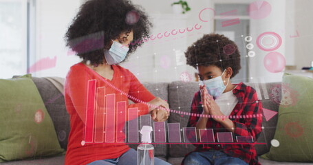 Image of diagram over biracial mother with son disinfecting hands with face masks