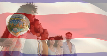 Image of flag of costa rica waving over diverse friends forming human chain at looking at sea