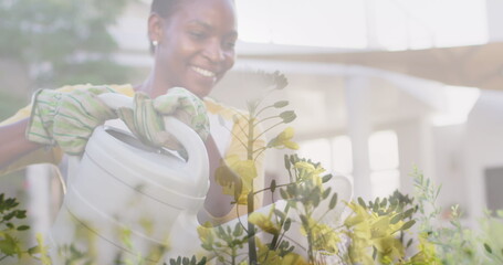 Image of plants waving over smiling african american woman watering garden