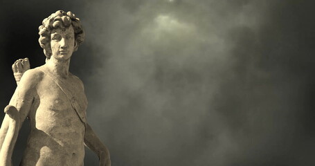 Image of gray sculpture of man over dark sky and clouds, copy space