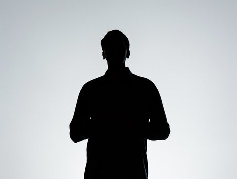 A man is standing in front of a white background