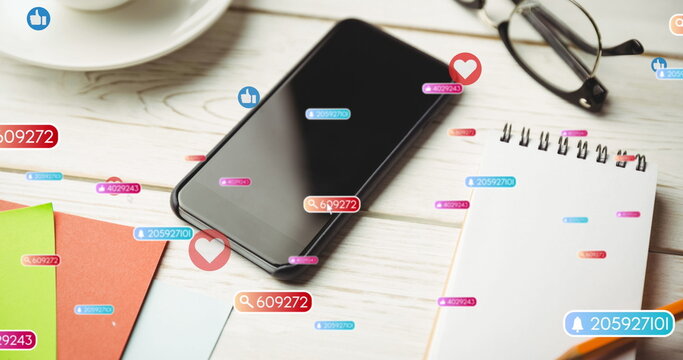 Image of social media like and love icons over smartphone on desk background