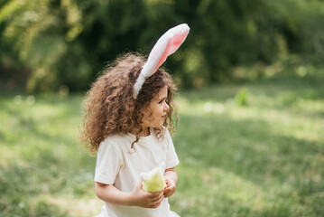 Easter egg hunt. Girl child Running To Pick Up Egg In Garden. Easter tradition. Baby with basket full of colorful eggs.