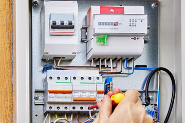 Connecting three-phase power cable for outdoor distribution board, during wiring installation in country house.