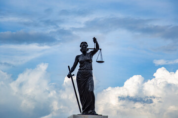 Sculpture of Lady Justice or Themis symbol of justice and law in Izmir Turkey, Femida outdoors against blue cloudy sky background copy space cut out