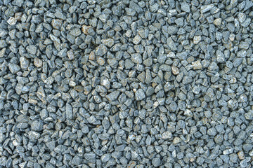 Gray pebbles in background, it was compacted to be smooth and used to make sidewalks.
