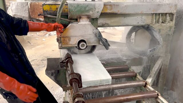 Operator cutting marble with cutter machine in factory