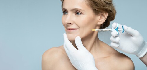 Skin tightening and face contour correction with beauty injections for middle-aging woman's face in cosmetology. Beauty injections