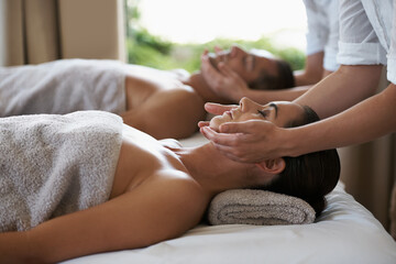 Hands, face massage and couple in spa to relax on bed for luxury pamper treatment together in...