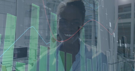Image of financial data processing over happy african american businesswoman
