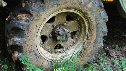 A close-up of a heavily mud-caked tire, highlighting the rugged tread pattern and the adventure of off-road driving.