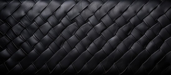 A close up of a black leather couch with a woven pattern, resembling a mesh of automotive tire material. The texture contrasts with electric blue tints, creating a modern and sleek look