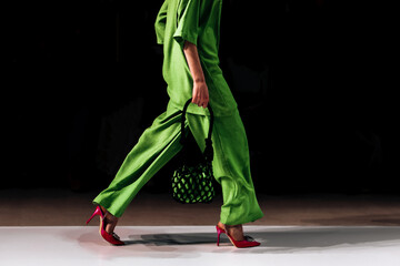 Details of a bright green stylish pants, blouse and red heels. Women's Elegant Casual Fashion