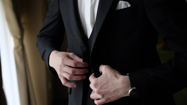 The man puts on a black jacket