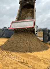 Truck dumping soil during construction at new home