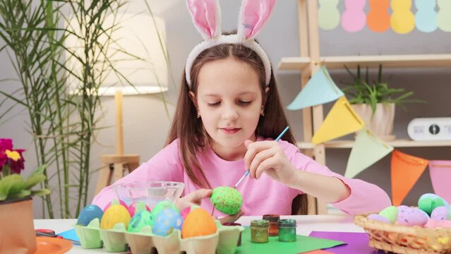 Easter egg decorations joy to children. little child wearing bunny ears headband painting easter eggs at home schoolgirl making creative egg designs for Easter celebrations