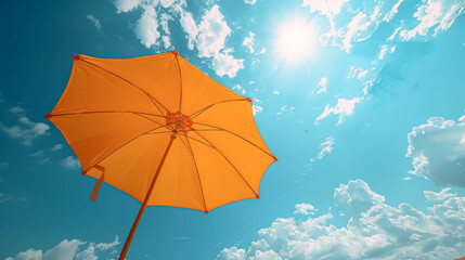 Orange umbrella outdoors with sunny blue sky, copy space.