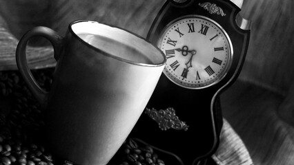 Cup of coffee and retro watch, black and white photo