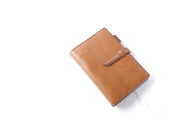 茶色の革のシステム手帳でデスクワークをしているイメージ