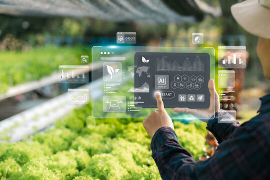 Agricultural technology concept, Ai system. A young man is working on a farm using a tablet controller with innovative technology for a smart farm system.