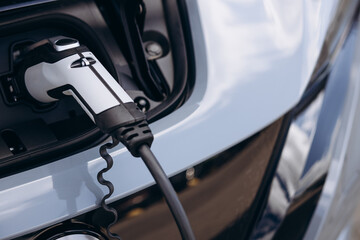 Close up photo of charging electric car with socket