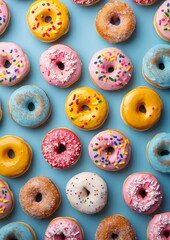Group of frosted donuts isolated on blue background. Frosting, glazed, sprinkled donuts. Sweet treats.