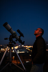 Amateur astronomer looking at the evening skies, observing planets, stars, Moon and other celestial...