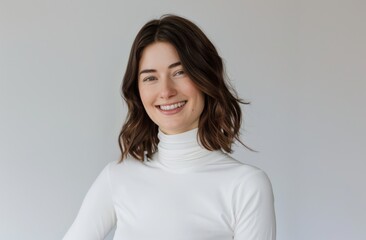 Fototapeta premium A woman is smiling and wearing a white shirt. She is posing for a picture. Concept of happiness and positivity